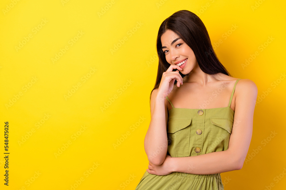 Fototapeta premium Portrait of adorable satisfied indonesian girl toothy smile finger touch lips empty space isolated on yellow color background