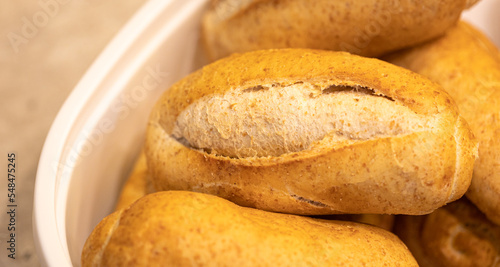 Pão Francês integral ou também conhecido por pão de sal integral no Brasil. Um grupo de pães franceses integrais em um cesto de plástico. Comida, Padaria, Alimentação saudável. photo
