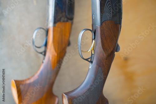 Two double-barreled shotguns stand on a stand. Weapon close-up, rifle for hunting.