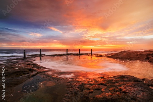 Beautiful sunrise over a natural ocean rock pool near Sydney Australia