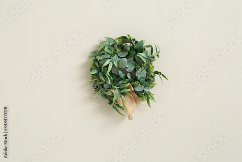 Christmas mistletoe wreath on light wall