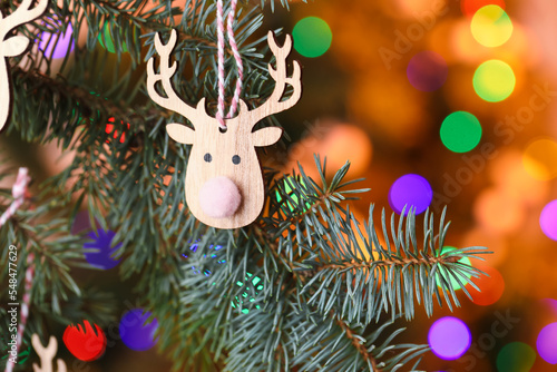 Christmas reindeer toy on fir tree, closeup