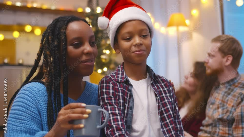 African-American woman and son in santa hat congratulating grandparents on christmas using video chat African-American woman and son in santa hat congratulating grandparents on christmas using video chat