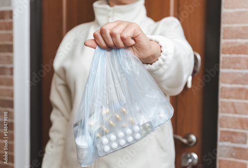 Woman's hand with a package of medicines. Medicamentation delivery, support and help concept. Close-up view photo