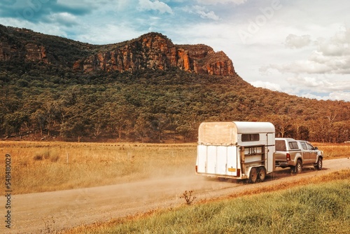 Horse float pulled by four wheel drive along a dirt road in rural Australia