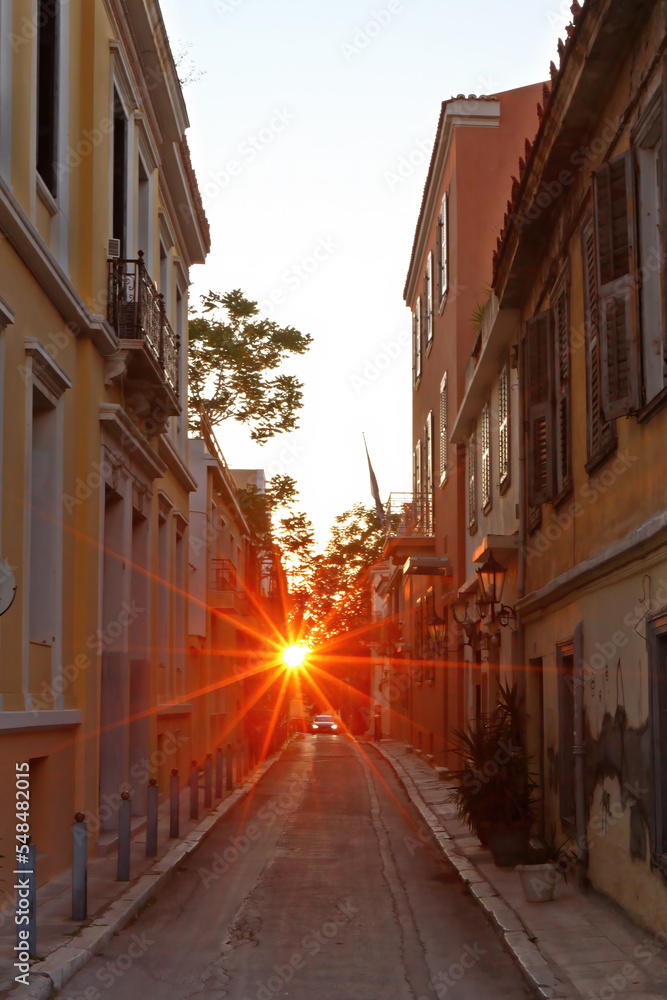Star-shaped sunlight during sunset in the picturesque district of Plaka, the Old Town of Athens, Greece, Europe. 