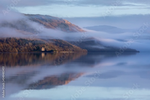 Low-angle of Dunderave castle on the foogy shores of the picturesque Loch Fyne, Scotland photo