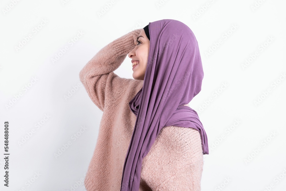 Φωτογραφία Profile photo of excited beautiful muslim woman wearing hijab and warm jumper ov