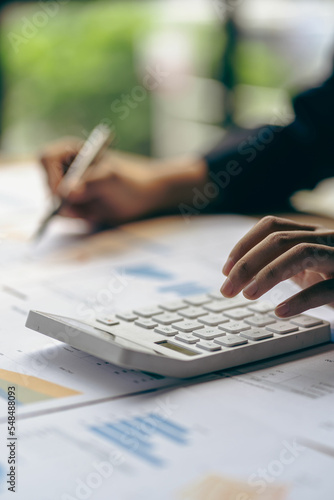 vertical view businessman hand holding a pen using a calculator Work with charts and analyze business strategies. financial statistics