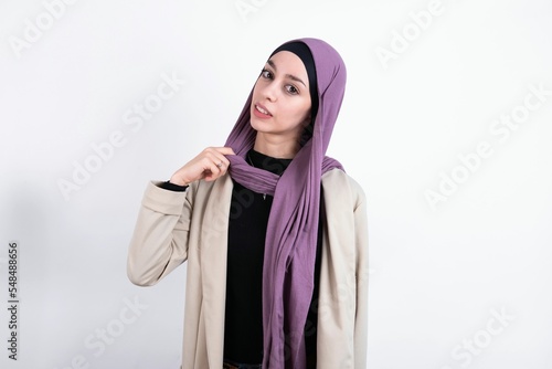young beautiful muslim woman wearing hijab and jacket over white background stressed, anxious, tired and frustrated, pulling shirt neck, looking frustrated with problem