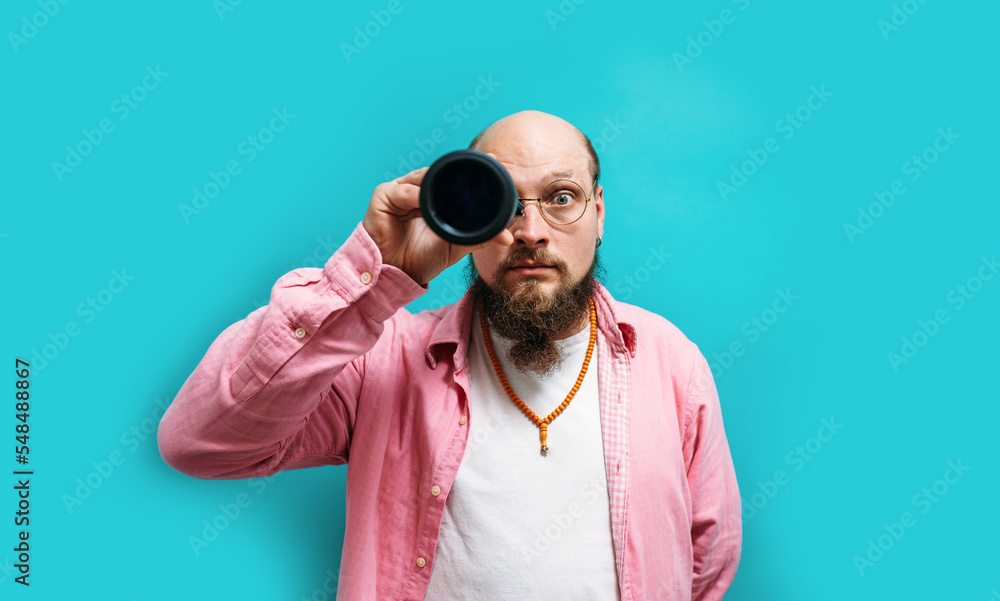 Crazy emotions. Young funny hipster tourist looking through a spyglass and considering the sights isolated on studio background. Looking for discounts, sale, seasonal sales. Colorful summer concept. Crazy emotions. Young funny hipster tourist looking through a spyglass and considering the sights isolated on studio background. Looking for discounts, sale, seasonal sales. Colorful summer concept.