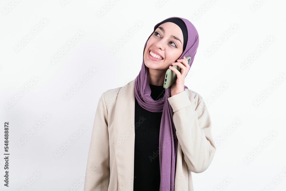 Φωτογραφία Pleasant looking happy young beautiful muslim woman wearing hijab and jacket ove