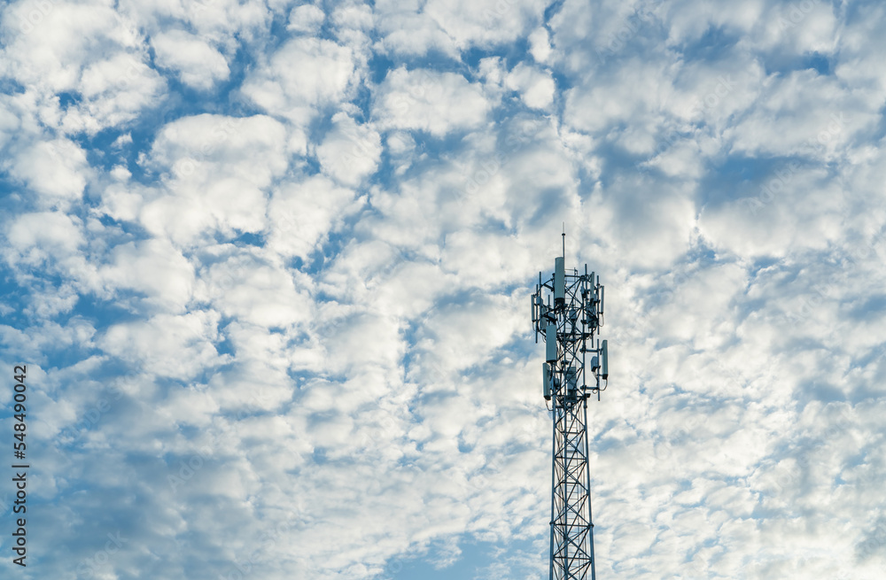Telecommunication tower with blue sky and white clouds background. Antenna on blue sky. Radio and satellite pole. Communication technology. Telecommunication industry. Mobile or telecom 4g network. Telecommunication tower with blue sky and white clouds background. Antenna on blue sky. Radio and satellite pole. Communication technology. Telecommunication industry. Mobile or telecom 4g network.