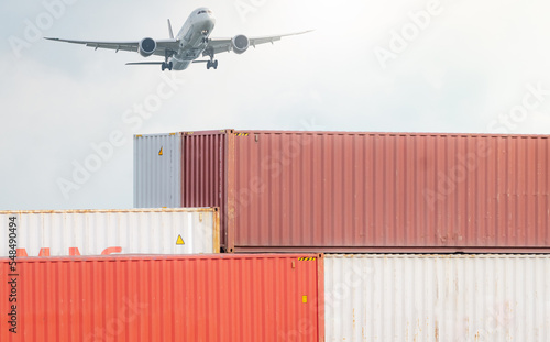 Air logistics. Cargo airplane flying above stack of logistic container. Cargo and shipping business. Container ship for export logistic. Logistic industry from port to port. Freight transportation.