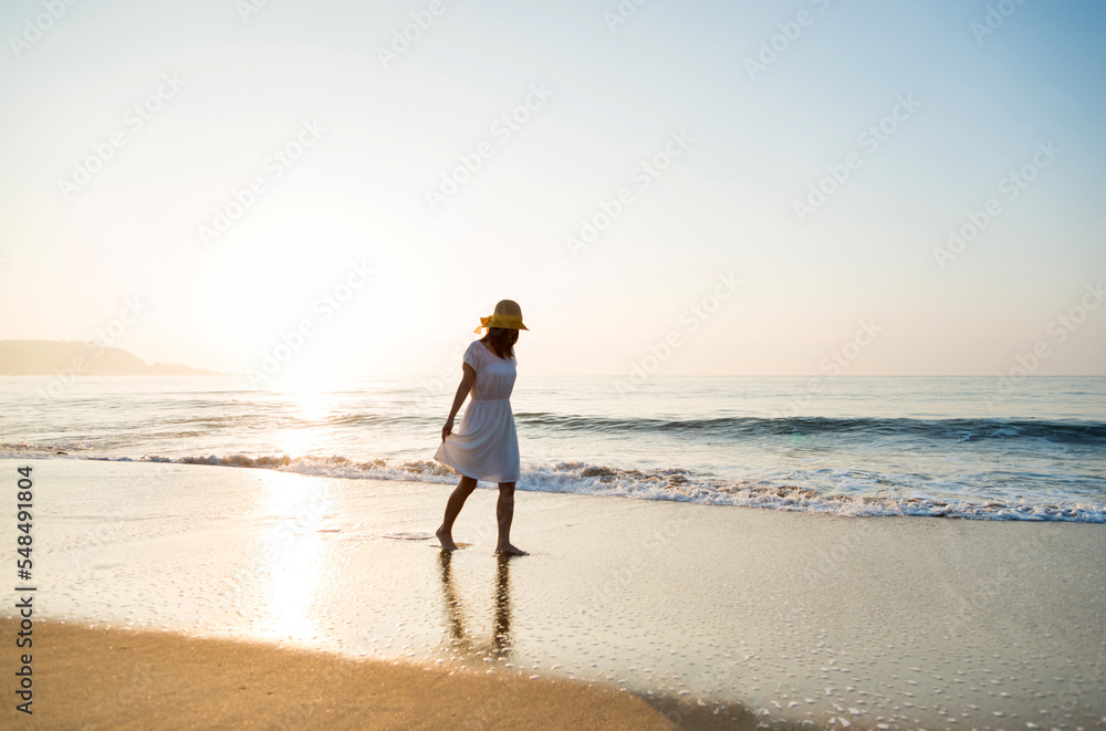 Young woman walking at the beach.