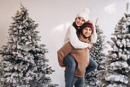A couple stay on the snow in the Christmas forest
