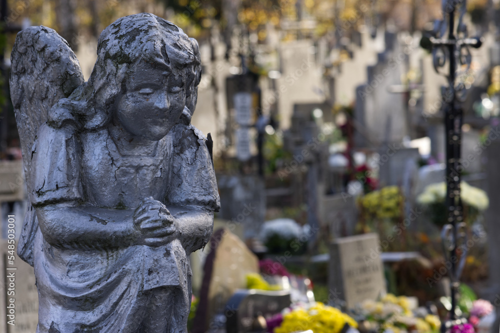 Closeup of stoned angel at cemetery. A sculpture of an angel in a cemetery Closeup of stoned angel at cemetery. A sculpture of an angel in a cemetery