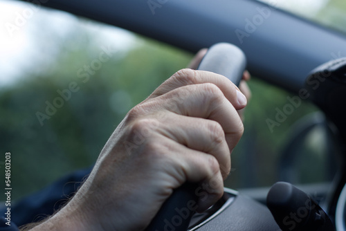 Close up of hands on steering wheel. Men driving the car. 