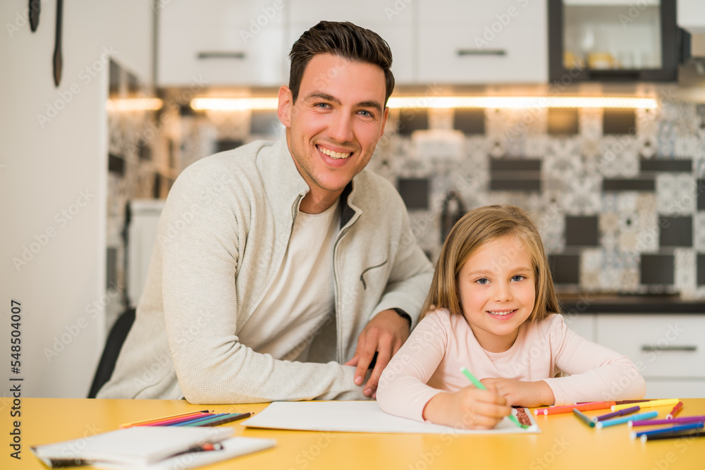 Fototapeta premium Little girl and her father enjoy drawing together at their home.