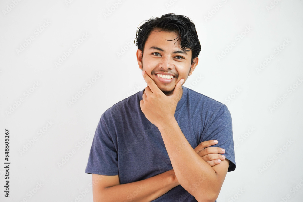 Handsome Asian man smiling and showing happy facial expression while holding his chin. Isolated on white background Handsome Asian man smiling and showing happy facial expression while holding his chin. Isolated on white background