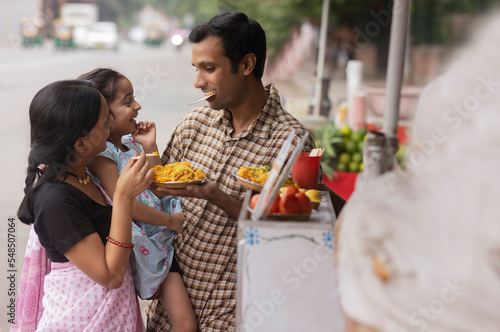 Portrait of happy family eating bhelpuri photo