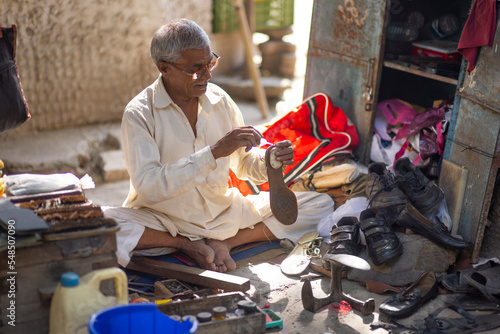 A cobbler repairing shoes on the streets of Delhi photo