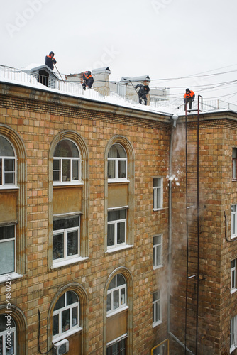 people clean the roof from snow in winter