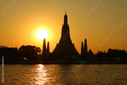 Stunning Bright Sun Shining on the Silhouette of Temple of the Dawn or Wat Arun, One of the the Best Known Landmark of Thailand © jobi_pro