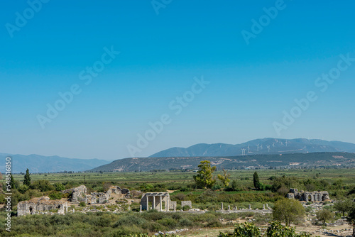View of the Ionic Stoa on the Sacred Way, in Miletus, Turkey. Ancient columns and ruins of ancient greek city on the blue sky background. Copy space for text.  photo