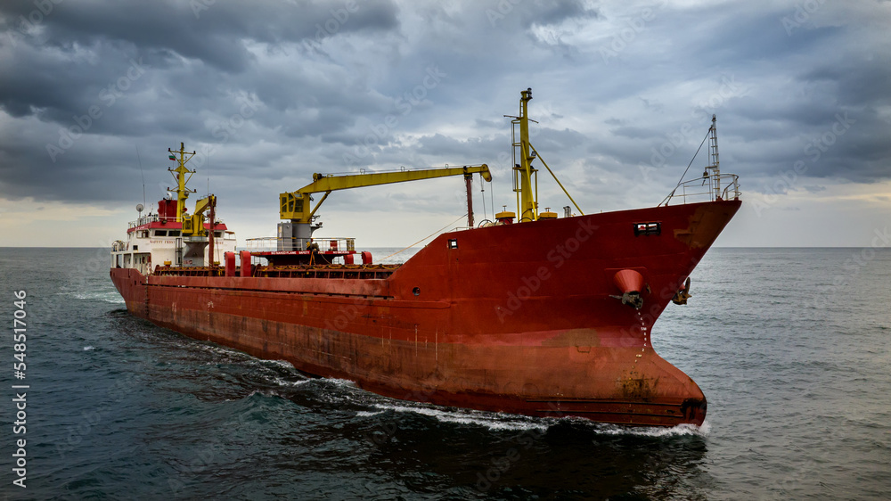 Large red cargo ship sailing in open sea Large red cargo ship sailing in open sea
