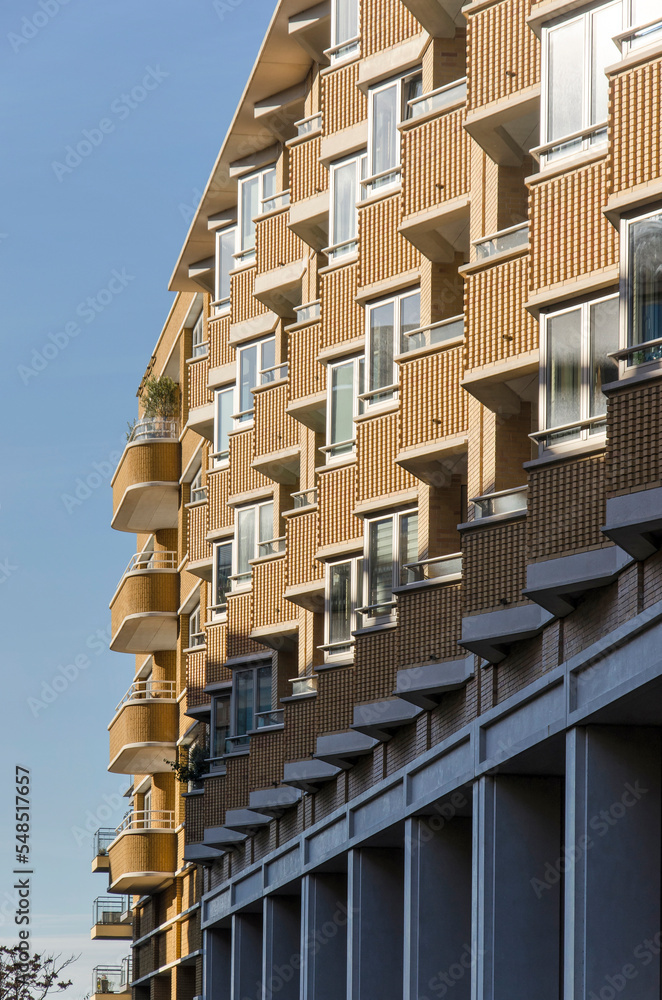Obraz premium Utrecht, The Netherlands, November 13, 2022: sculptural facade of a housing block with balconies and bay windows in yellow brick in the center of Leidsche Rijn district