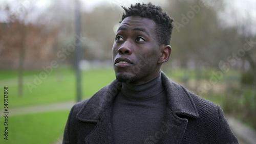Young black man walking outside in nature during winter season