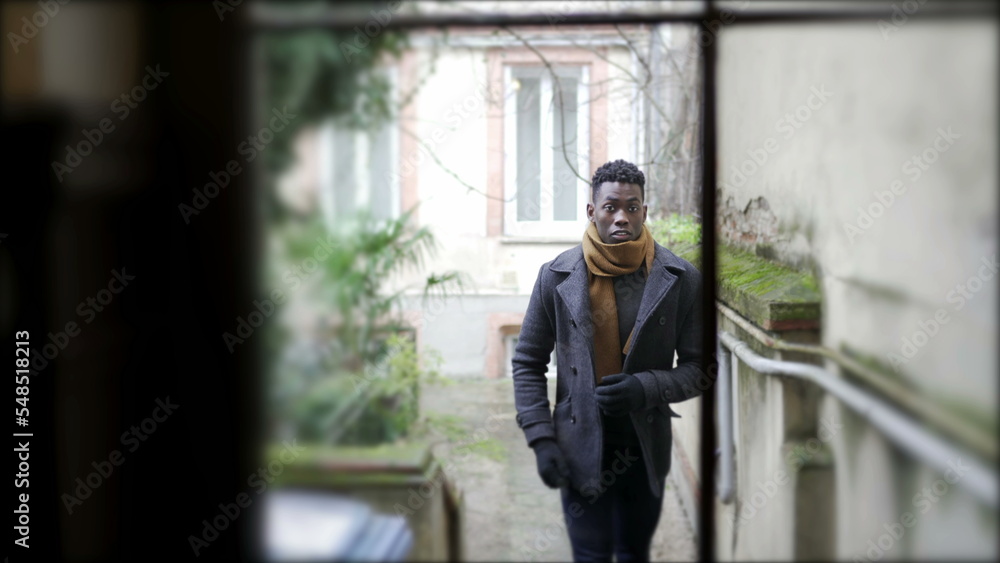 Young black man walking through corridor leaving home going outside. person leaving home Young black man walking through corridor leaving home going outside. person leaving home