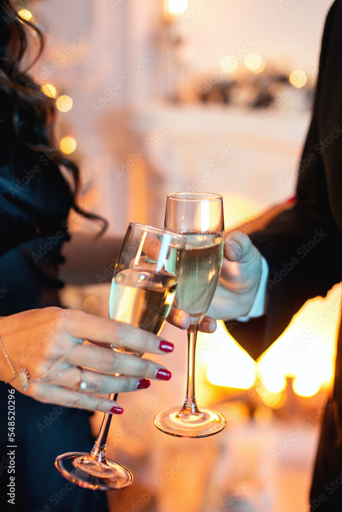 Close up shot of an elegant couple toasting glasses with champagne