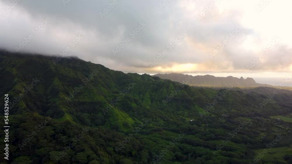 Cinematic nature aerial view of green mountains under tropical rain clouds at beautiful sunrise on Kauai island, Hawaii Dramatic nature aerial view of Rainforest Tropical jungle of Kauai. Cinematic nature aerial view of green mountains under tropical rain clouds at beautiful sunrise on Kauai island, Hawaii Dramatic nature aerial view of Rainforest Tropical jungle of Kauai.