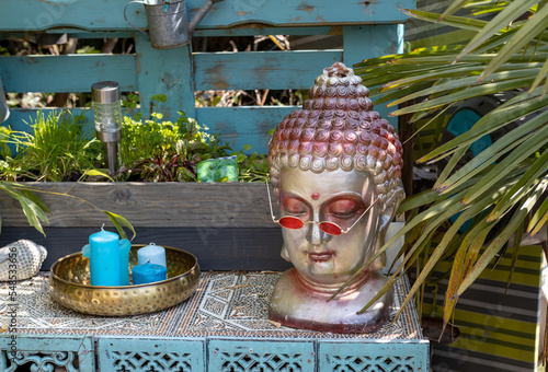 Buddha Deko mit Sonnenbrille im Garten