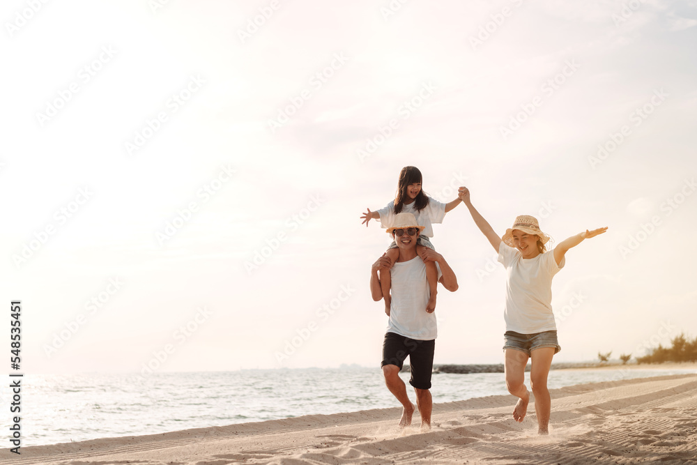 Happy asian family enjoy the sea beach at consisting father, mother and daughter having fun playing beach in summer vacation on the ocean beach. Happy family with vacations time lifestyle concept. Happy asian family enjoy the sea beach at consisting father, mother and daughter having fun playing beach in summer vacation on the ocean beach. Happy family with vacations time lifestyle concept.