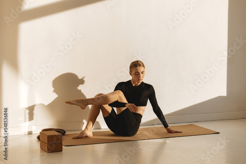 Wellness exercise, woman on floor mat stretching alone, workout day. Fitness training motivation in sunlight, health instructor stretching and athlete balance lifestyle