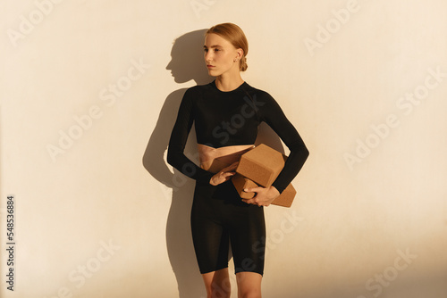 Wellness exercise, woman on floor mat stretching alone, workout day. Fitness training motivation in sunlight, health instructor stretching  and athlete balance lifestyle