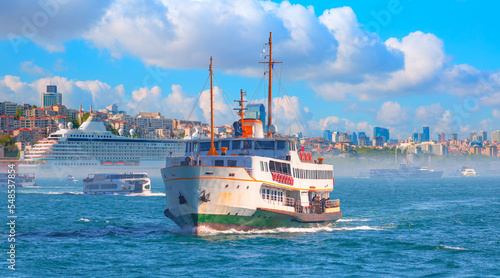 Cruise ship and ferry (steamboat) traffic in the Bosphorus - Sea voyage with old ferry (steamboat) on the Bosporus - Coastal cityscape with modern buildings under cloudy sky - Istanbul, Turkey 