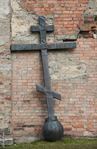 Old church in the Russian city of Volkhov. Restoration is underway now. The metal cross is leaning against the wall.