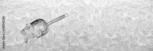 Close up stainless ice scoop with ice cubes in bucket top view use for food and beverage background	
