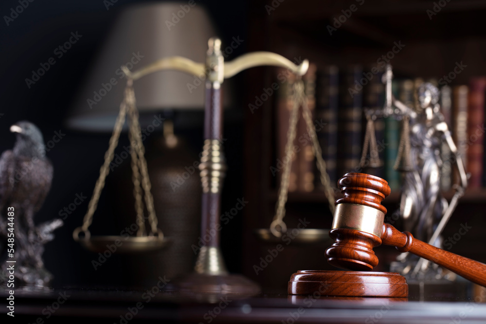 Lawyer office. Judge’s gavel, Themis sculpture and legal books in the bookshelf. Lawyer office. Judge’s gavel, Themis sculpture and legal books in the bookshelf.