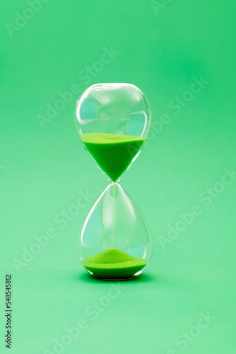 A hourglass on green background