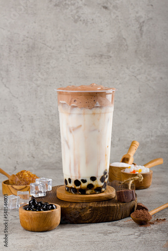 Boba or tapioca pearls is taiwan bubble milk tea in plastic cup with dalgona coffee flavor on texture  background, summers refreshment.