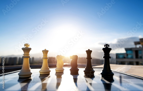 Black and white chess pieces on city background