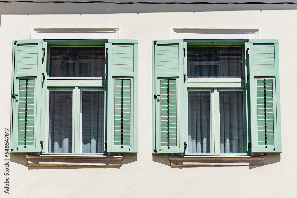 Mediterranean home with open green shutters made of wood. Retro rustic windows style Mediterranean home with open green shutters made of wood. Retro rustic windows style