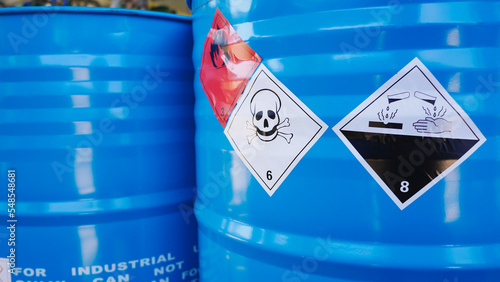Flammable, acid, volatile, warning labels, mounted on hazardous chemical storage tanks in the warehouse of a chemical industrial factory plant. Waiting for delivery according to the user\'s order.