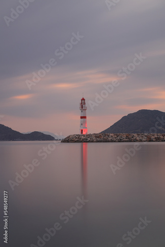 Seascape at sunset. Lighthouse on the coast. the lighthouse used for signage and its reflection in the sea. Beacon. Seaside town of Turgutreis and spectacular sunsets. 