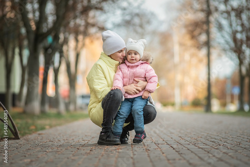 Portrait of a beautiful charming young mother with her daughter in the spring park.